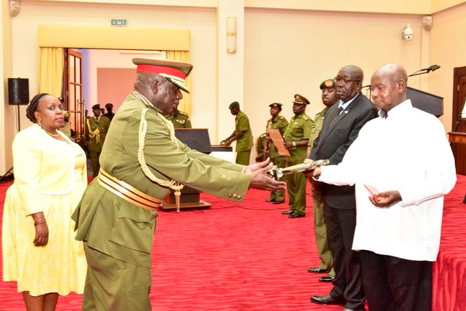 Museveni hands a plaque to one of the retired UPDF Generals
