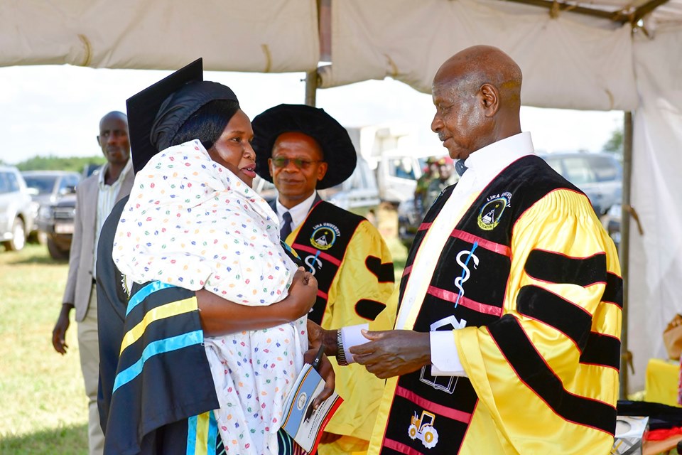 Museveni interacts with one of the graduands as Min. for Higher Education J C Miyingo looks on