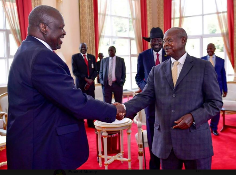 President Yoweri Museveni and Riek Machar shake hands